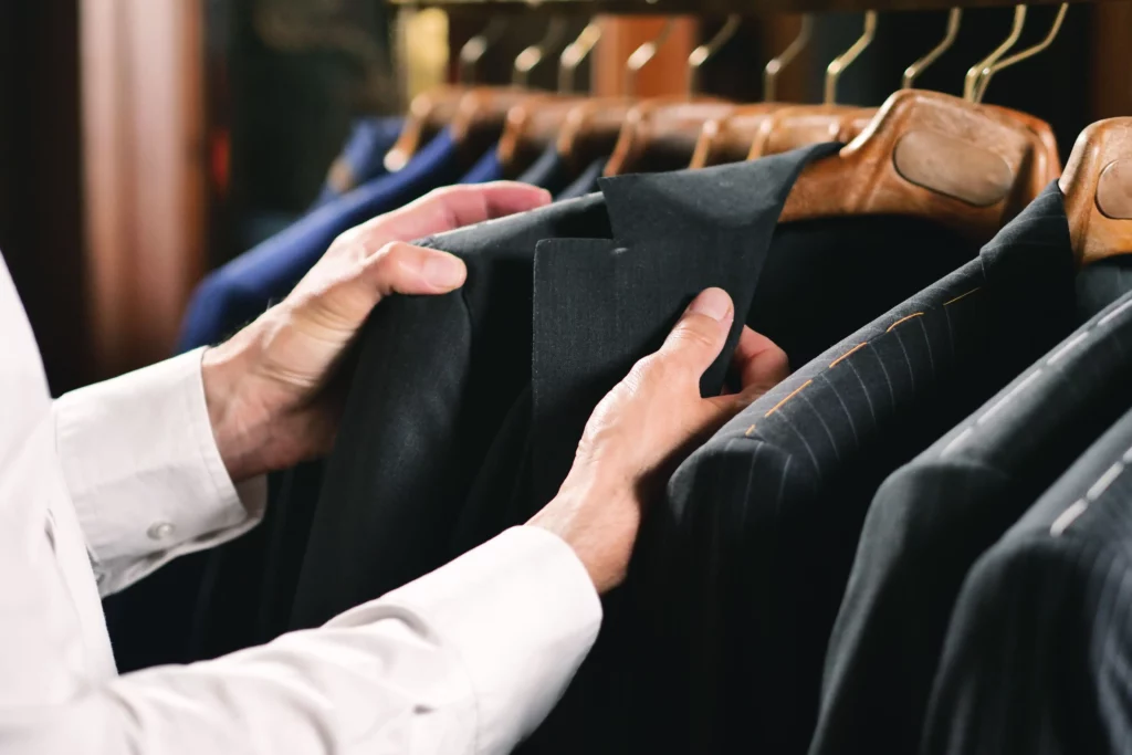customer-looking-and-feeling-custom-suits-in-a-store