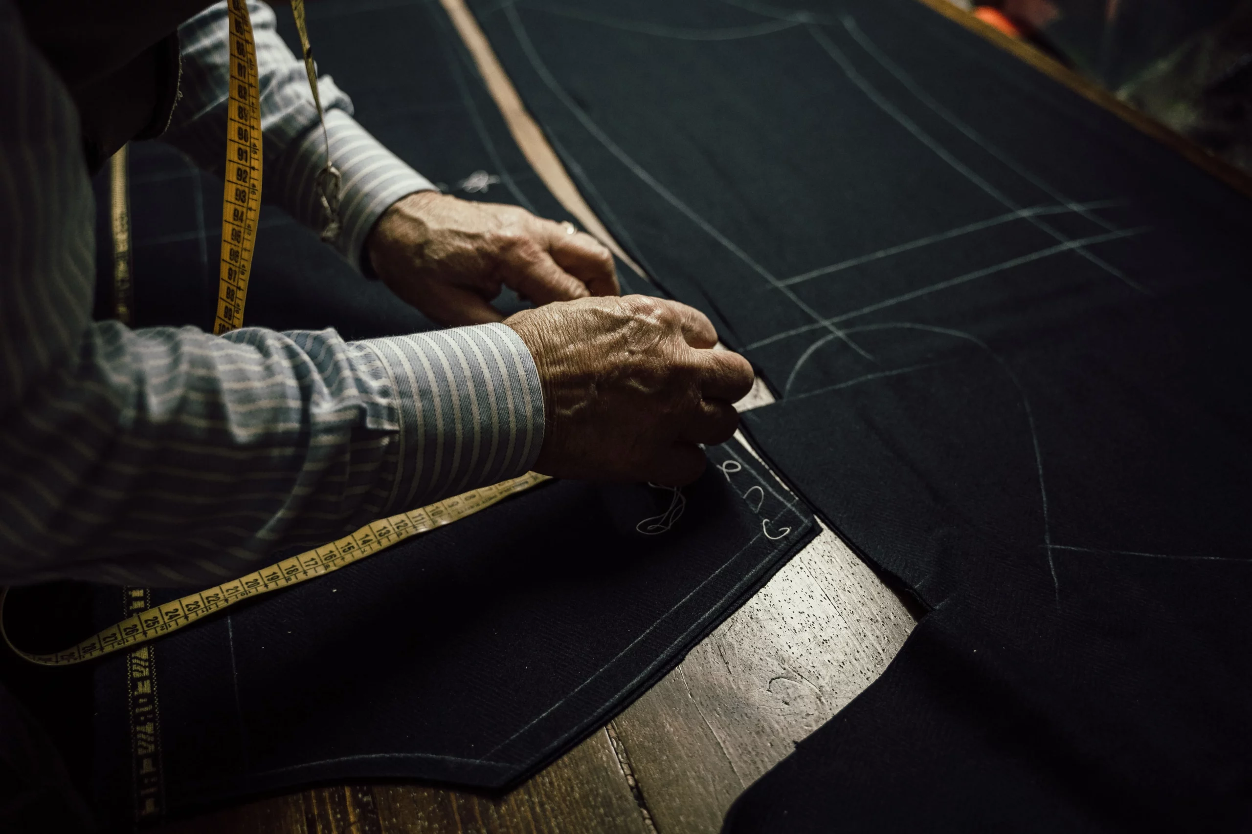 Step three. Showing a custom suit tailor chalking and cutting fabric for a suit from Carl Axen Clothier Custom Suits of Orlando